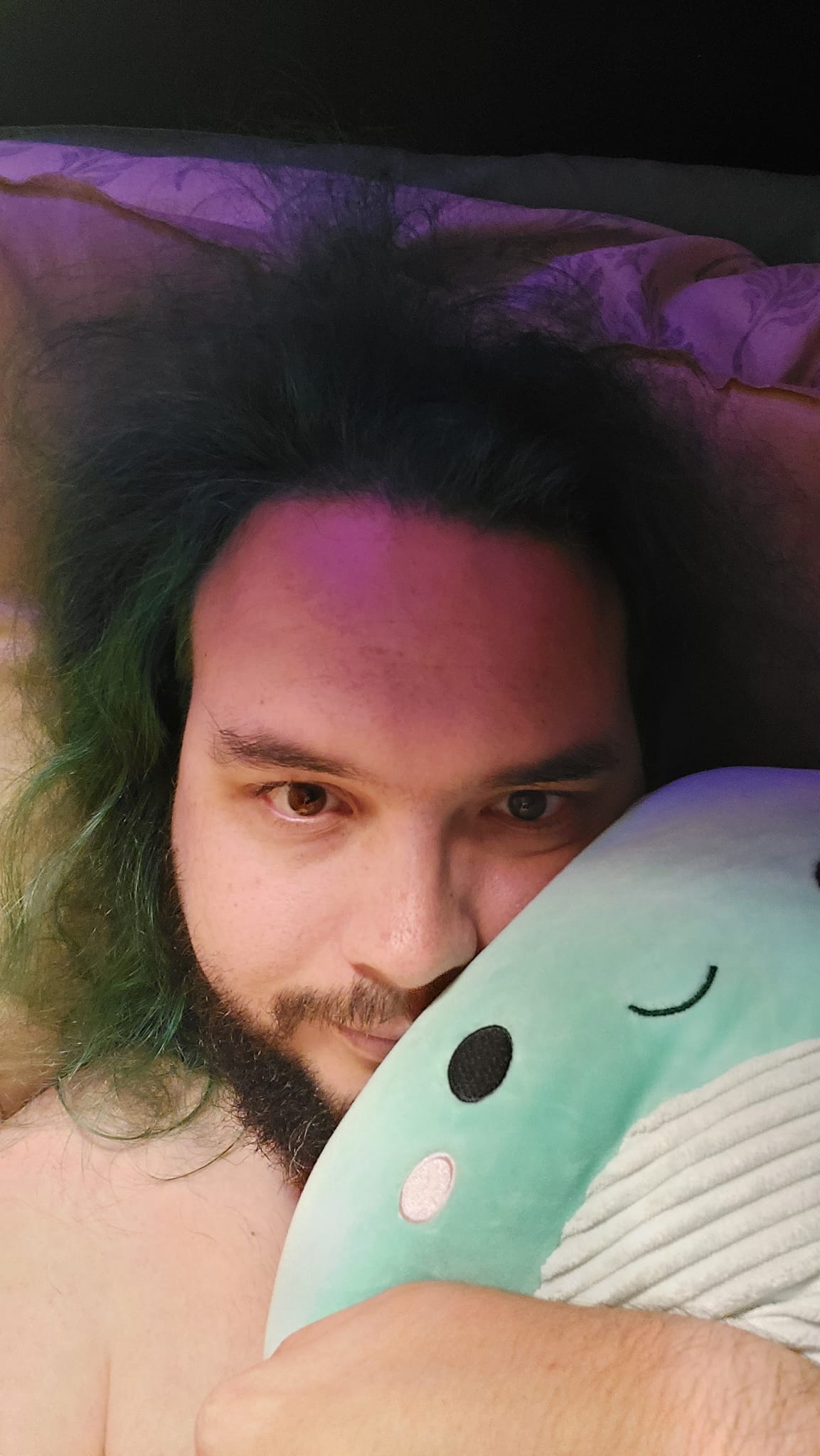 A man with green hair is holding a green Nessie Squishmallow, photo 6